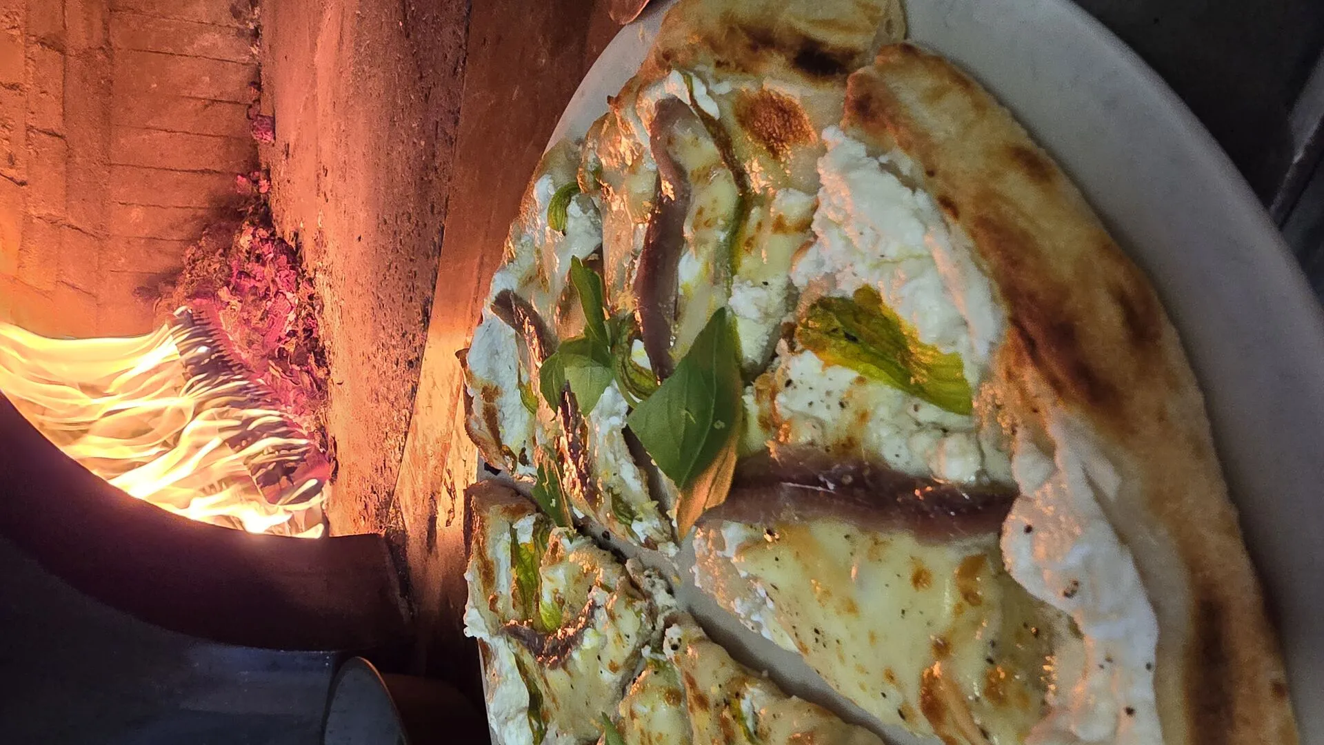Preparazione pizza artigianale nel forno a legna